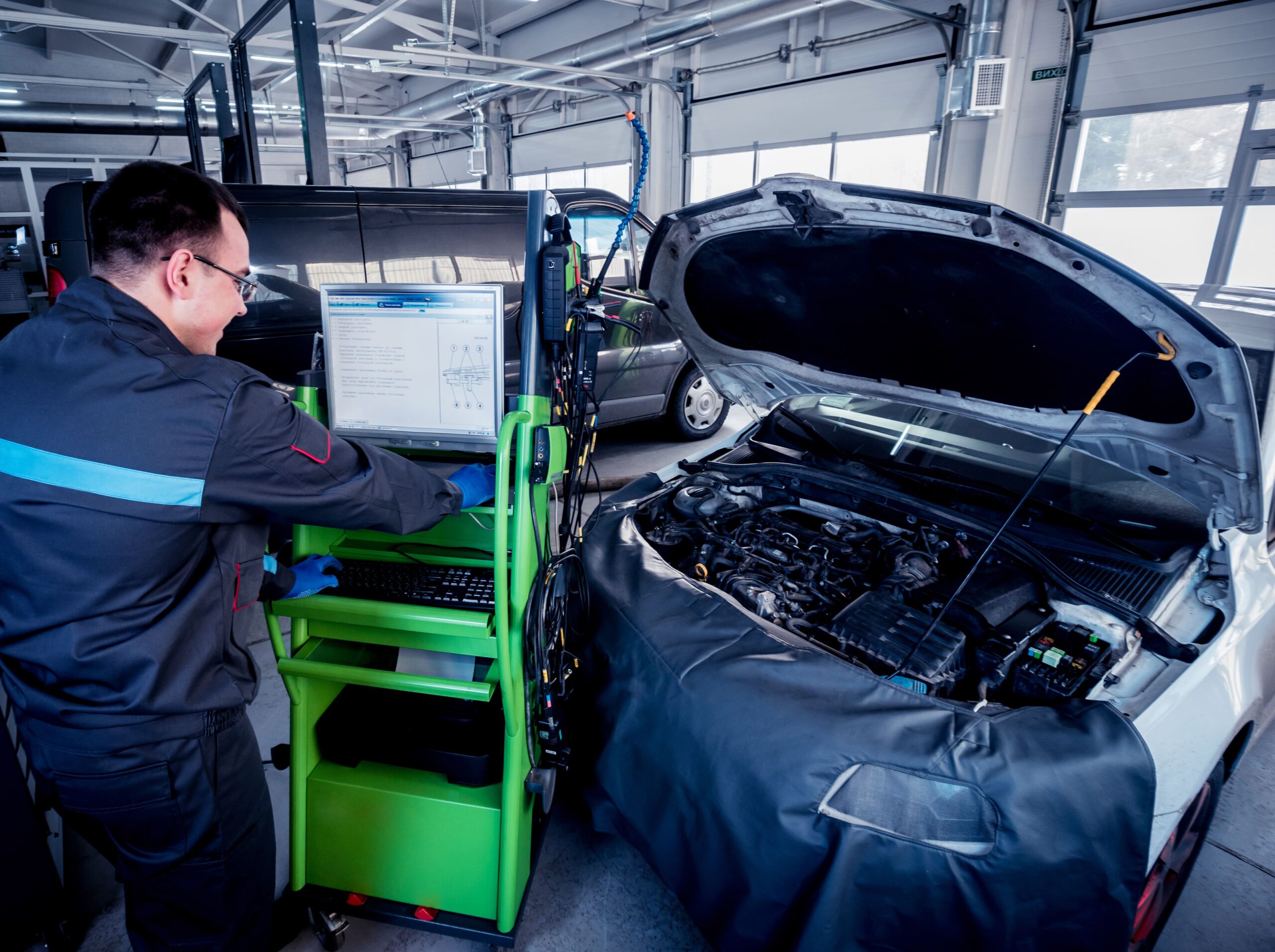 Mécanicien automobile vérifiant le bon fonctionnement d'un moteur de voiture en réparation